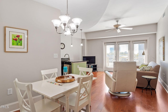 dining room featuring dark hardwood / wood-style flooring and ceiling fan with notable chandelier