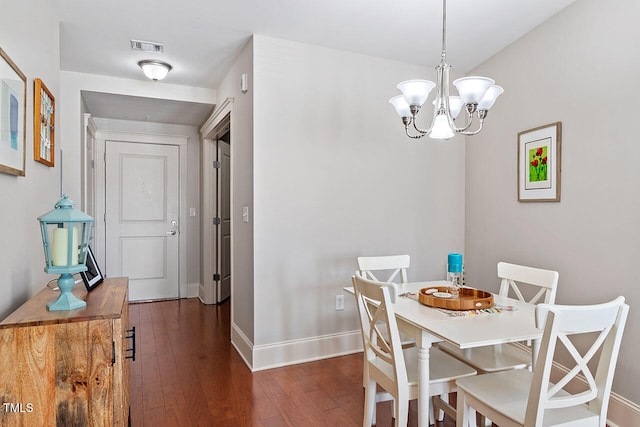 dining area with an inviting chandelier and dark wood-type flooring