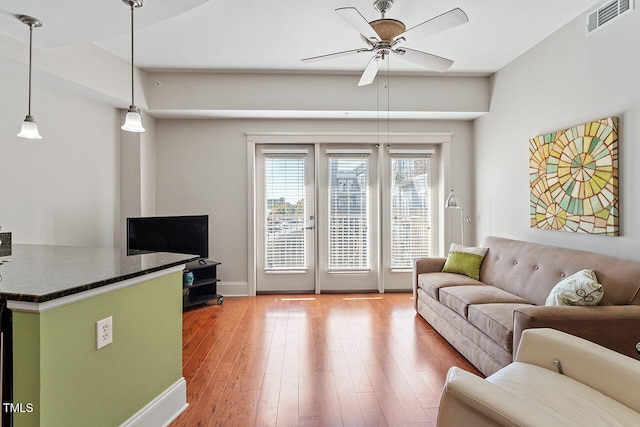 living room featuring wood-type flooring and ceiling fan