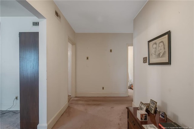 hall with light colored carpet