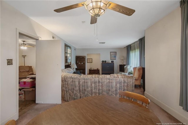 dining space featuring light colored carpet, ceiling fan, and plenty of natural light