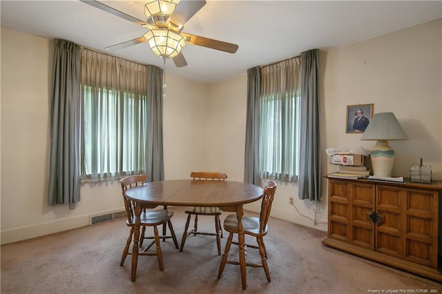 carpeted dining room featuring ceiling fan