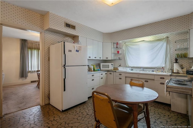 kitchen featuring white cabinets, white appliances, sink, and dark carpet