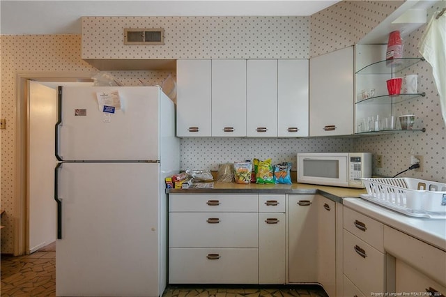 kitchen with white cabinetry and white appliances