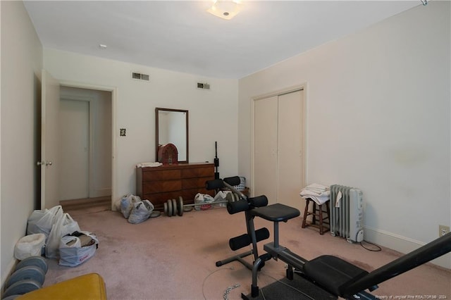 exercise room with light colored carpet and radiator heating unit