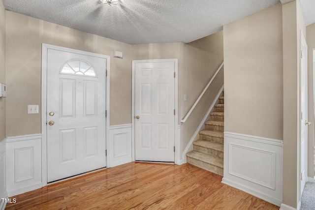 foyer featuring a textured ceiling and light hardwood / wood-style flooring