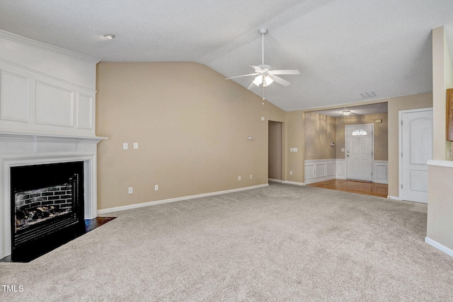 unfurnished living room with a textured ceiling, carpet floors, ceiling fan, and lofted ceiling