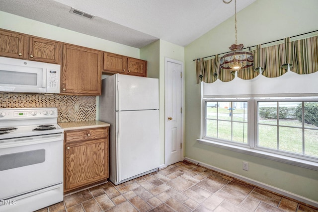 kitchen featuring tasteful backsplash, white appliances, lofted ceiling, a notable chandelier, and pendant lighting