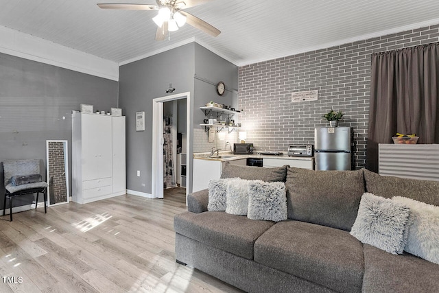 living room with brick wall, ceiling fan, crown molding, sink, and light hardwood / wood-style floors