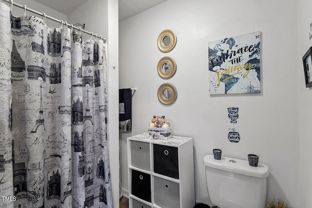 bathroom featuring curtained shower and toilet