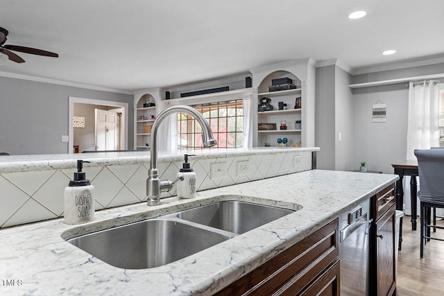 kitchen featuring ceiling fan, sink, light stone counters, light hardwood / wood-style floors, and ornamental molding