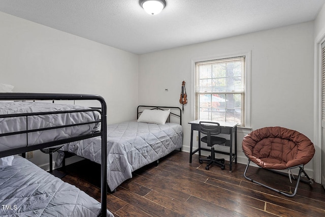 bedroom featuring dark hardwood / wood-style flooring and a textured ceiling