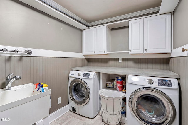 clothes washing area featuring washing machine and dryer, sink, and cabinets