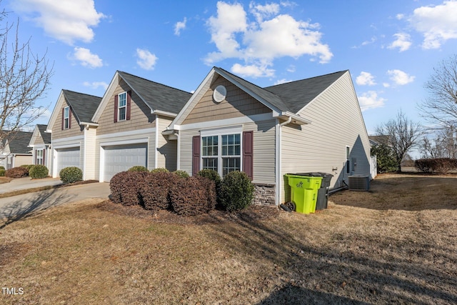 view of front of home featuring a garage, a front yard, and central AC unit