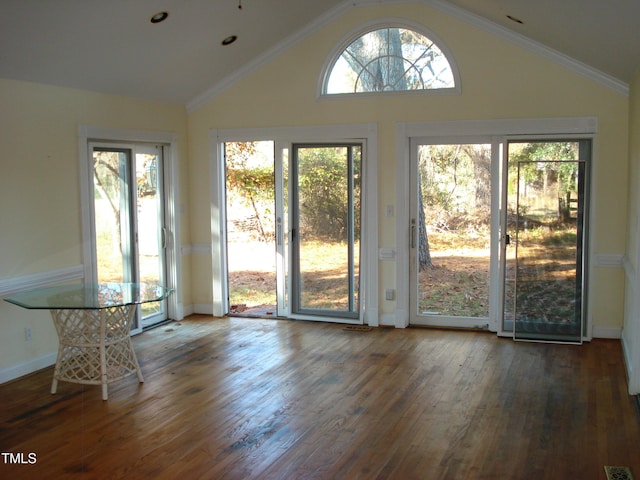 entryway featuring dark wood-type flooring, a wealth of natural light, lofted ceiling, and crown molding