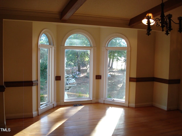 doorway with beam ceiling, an inviting chandelier, and plenty of natural light