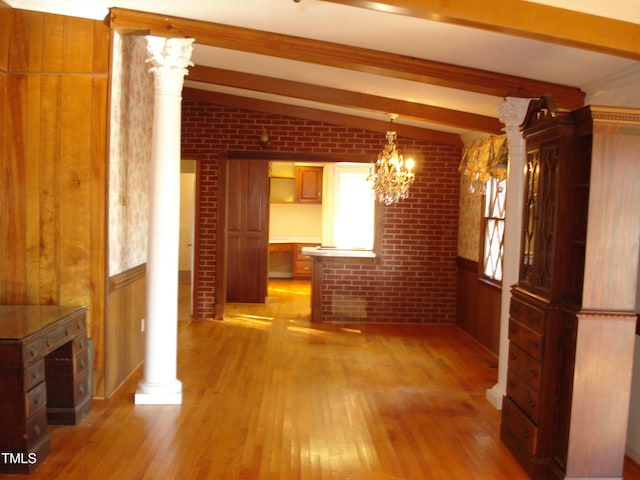 unfurnished dining area with lofted ceiling with beams, brick wall, decorative columns, and light hardwood / wood-style flooring