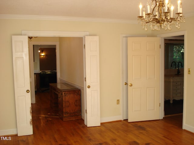 unfurnished bedroom featuring ornamental molding, dark hardwood / wood-style floors, and an inviting chandelier