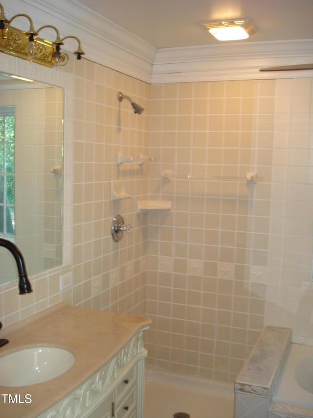 bathroom with tiled shower, sink, and ornamental molding