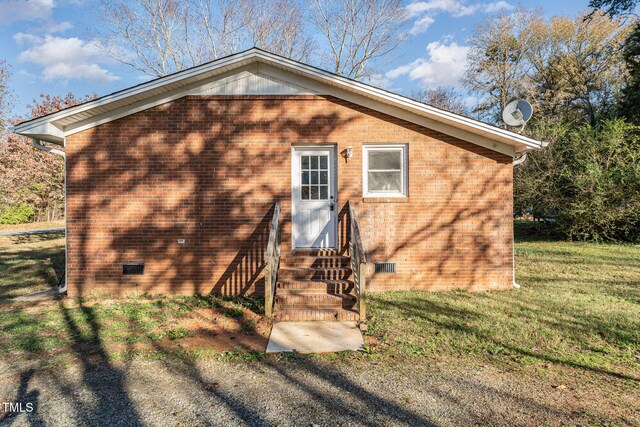 rear view of house featuring a yard