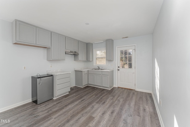 kitchen featuring gray cabinets, stainless steel fridge, light hardwood / wood-style flooring, and sink