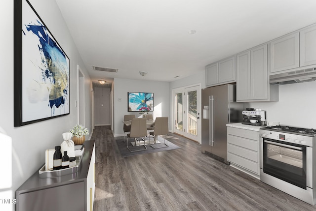 kitchen featuring stainless steel appliances, dark hardwood / wood-style floors, and gray cabinetry