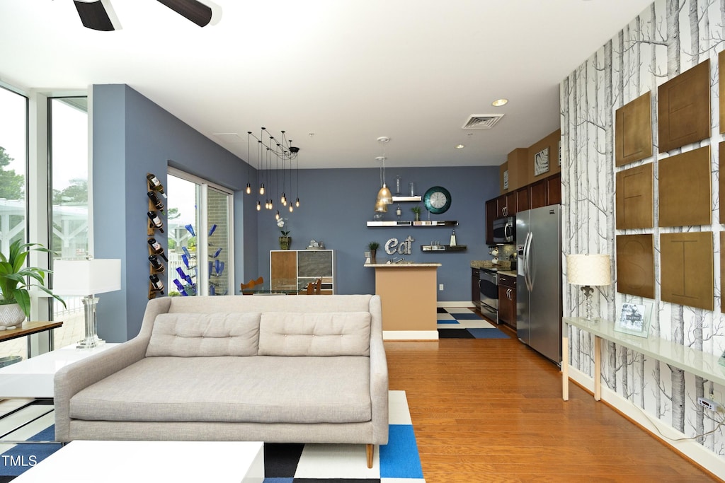 living room featuring wood-type flooring and ceiling fan