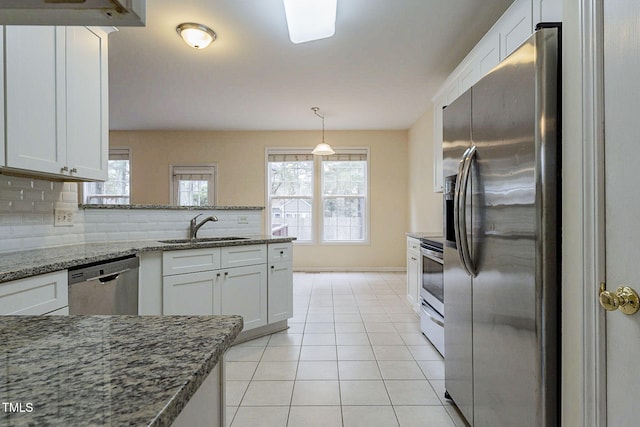 kitchen with tasteful backsplash, white cabinetry, sink, stainless steel appliances, and light stone counters