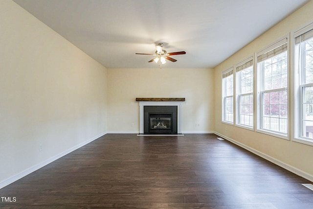 unfurnished living room with ceiling fan and dark hardwood / wood-style flooring