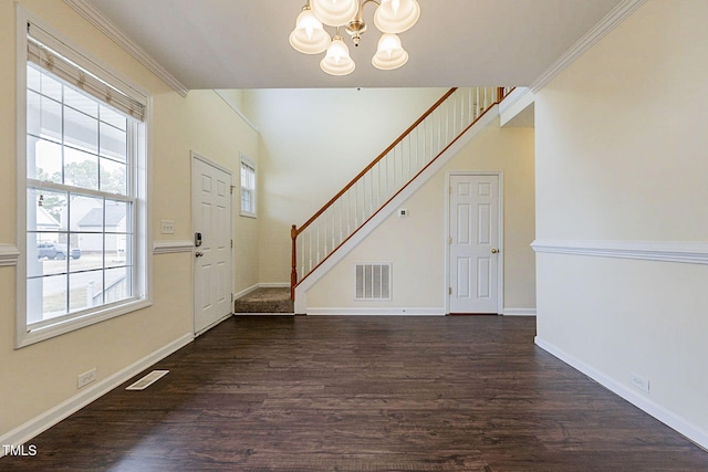 entryway with a chandelier, crown molding, and dark hardwood / wood-style floors