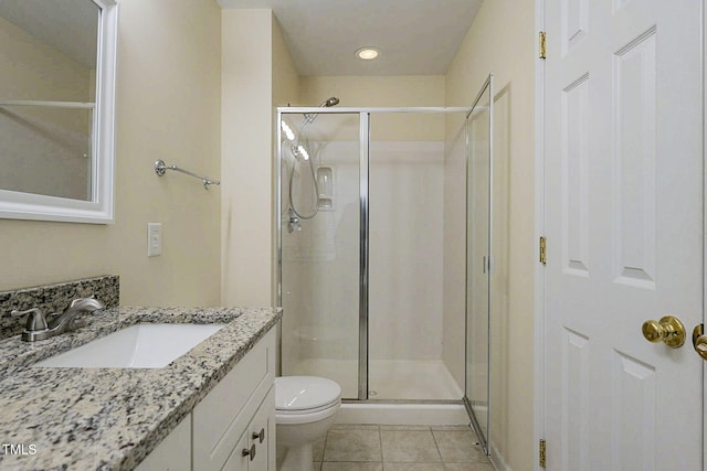 bathroom featuring vanity, toilet, walk in shower, and tile patterned flooring