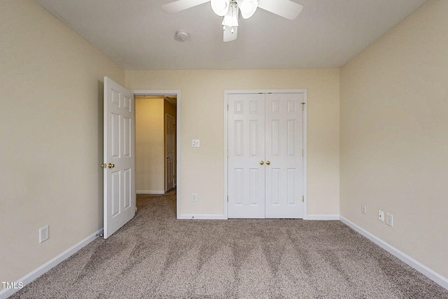 unfurnished bedroom with carpet, a closet, and ceiling fan