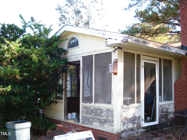 view of home's exterior with a sunroom