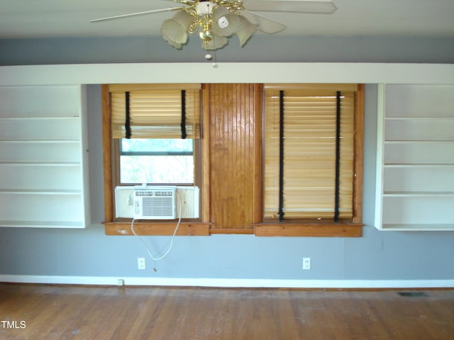 unfurnished room with cooling unit, wood-type flooring, and ceiling fan