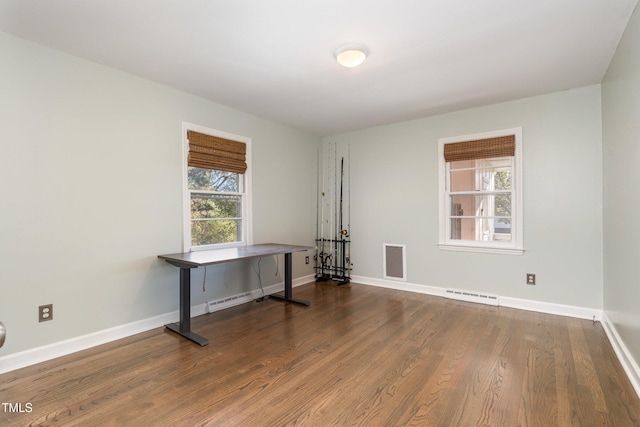 spare room featuring hardwood / wood-style floors and plenty of natural light