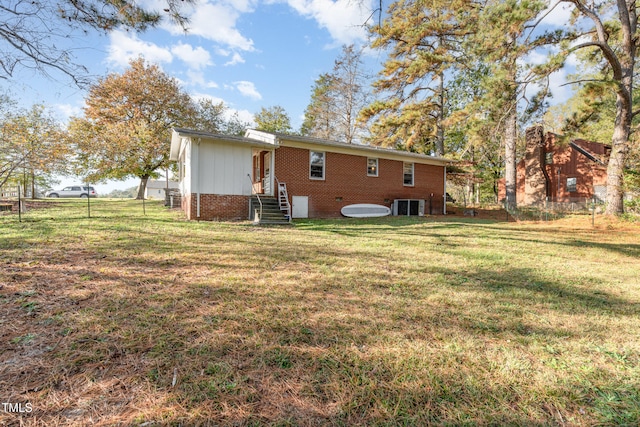 back of property with a yard and central air condition unit