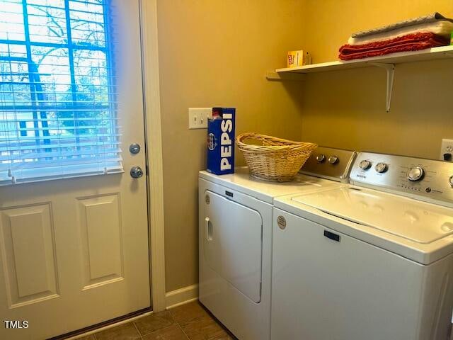 laundry area with separate washer and dryer and dark tile patterned flooring