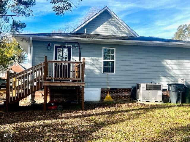 back of house with cooling unit and a yard