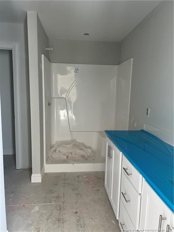 bathroom featuring a shower and vanity