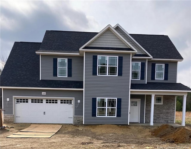 view of front of house featuring a garage, stone siding, and a shingled roof