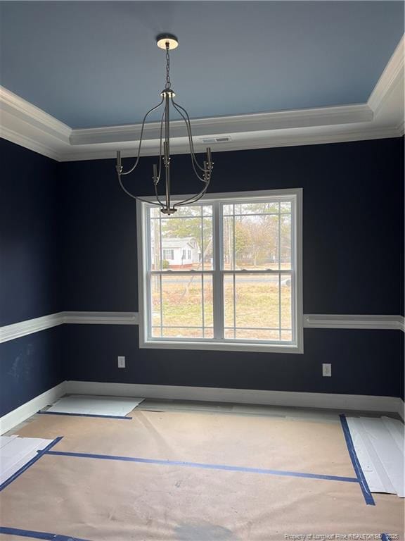 unfurnished dining area with ornamental molding, a tray ceiling, a chandelier, and baseboards