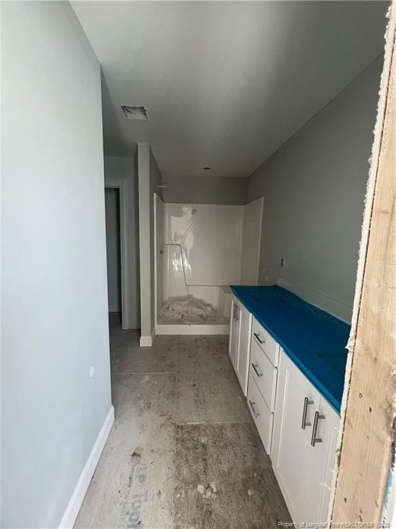 full bathroom featuring a stall shower, baseboards, and vanity