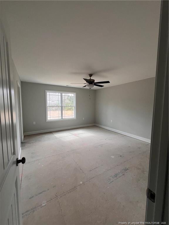 unfurnished room with ceiling fan and baseboards