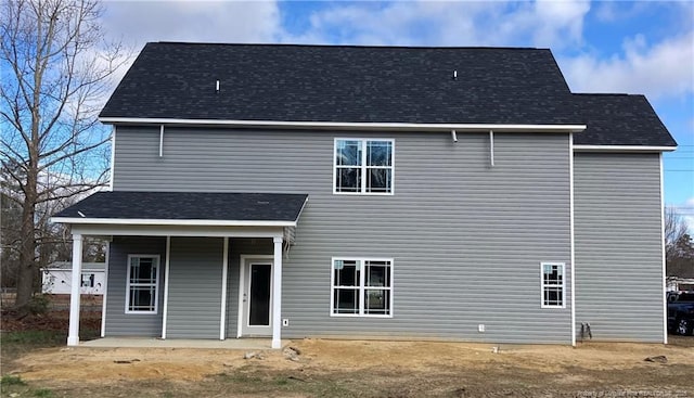 back of property with a shingled roof