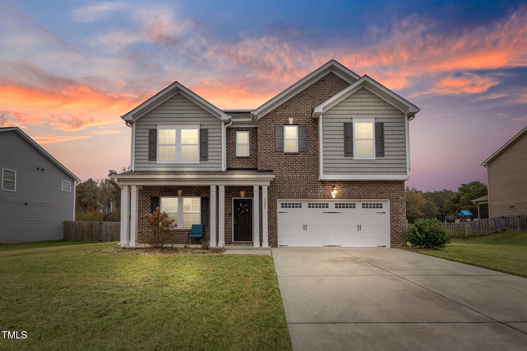 view of front of property featuring a garage and a lawn