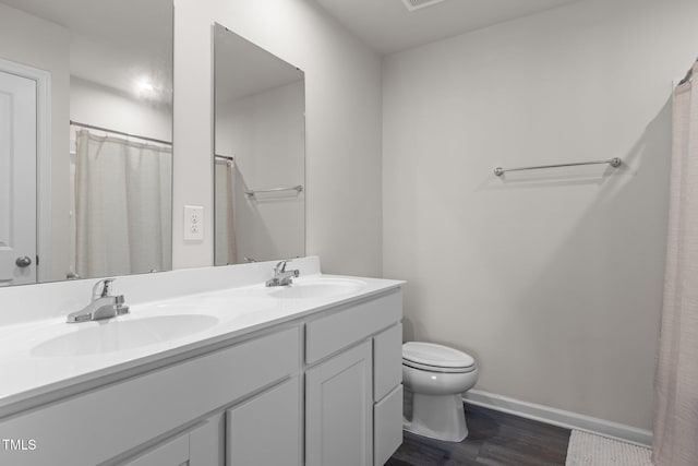 bathroom featuring a shower with shower curtain, wood-type flooring, vanity, and toilet