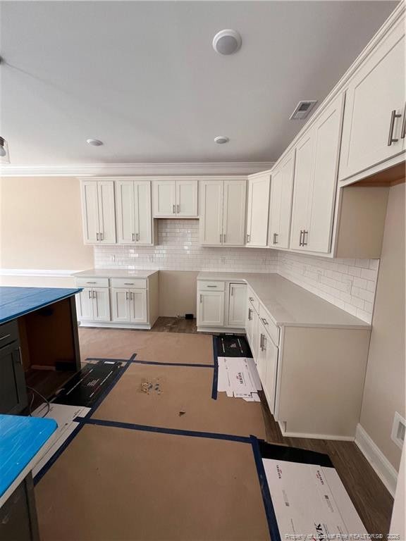 kitchen with white cabinets, visible vents, and decorative backsplash