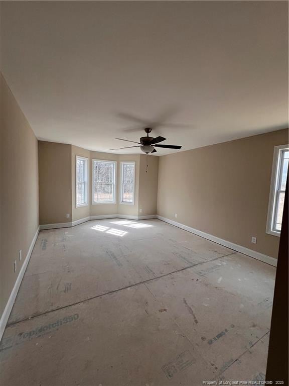 spare room with a healthy amount of sunlight, ceiling fan, and baseboards