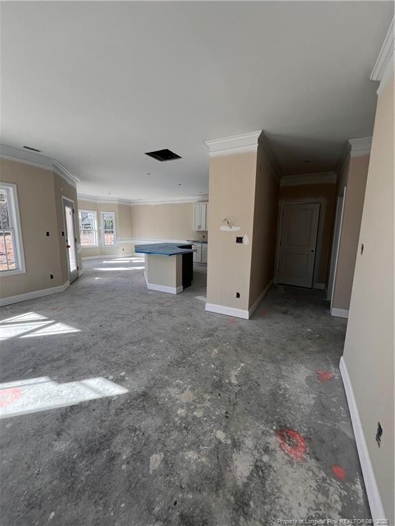 unfurnished living room with baseboards and crown molding