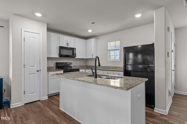 kitchen with sink, black appliances, white cabinetry, and an island with sink